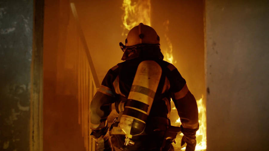 A Hero's Ascent - Firefighter Climbing The Stairs In Action. Wallpaper