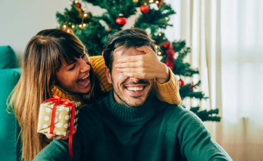 A Joyous Stack Of Christmas Presents Under The Sparkling Christmas Tree Wallpaper