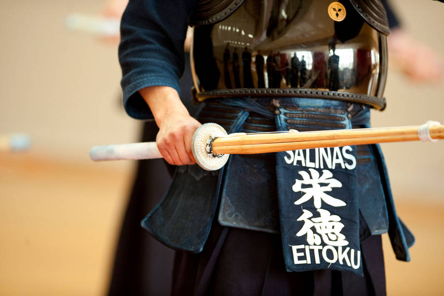 A Kendo Practitioner Holds A Bamboo Sword (shinai) Wallpaper