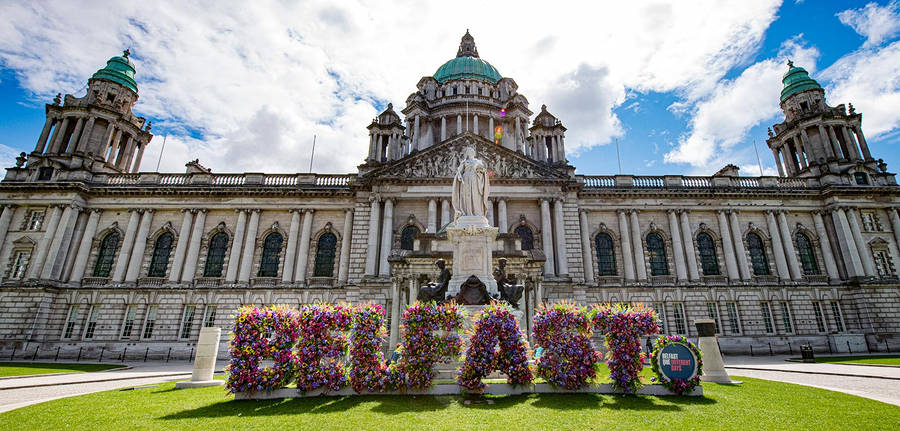 A Large Building With Flowers In Front Of It Wallpaper