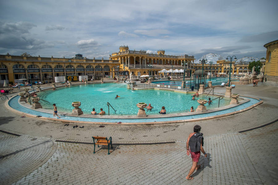 A Large Pool With People Walking Around It Wallpaper