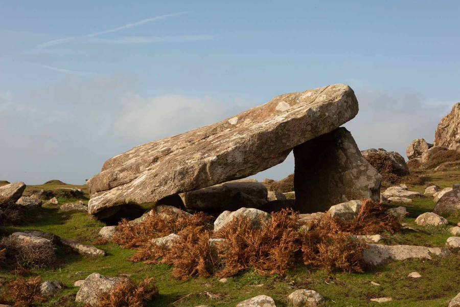 A Large Rock Formation On A Grassy Hill Wallpaper