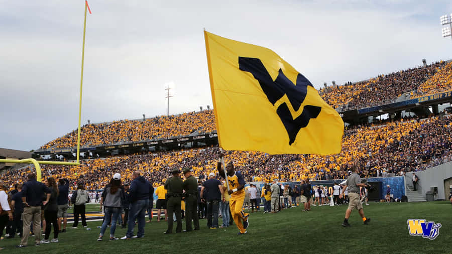 A Large Yellow Flag Is Held Up By A Crowd Of People Wallpaper