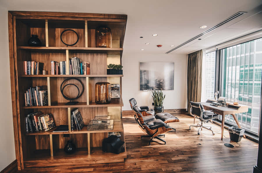 A Living Room With A Bookcase And A Chair Wallpaper