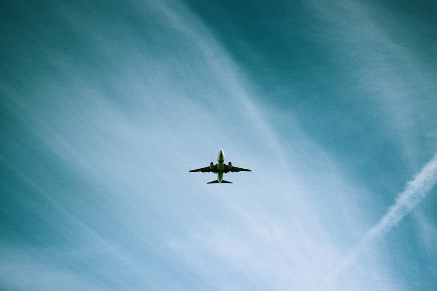 A Low Angle View Of A Plane Flying Through The Sky Wallpaper