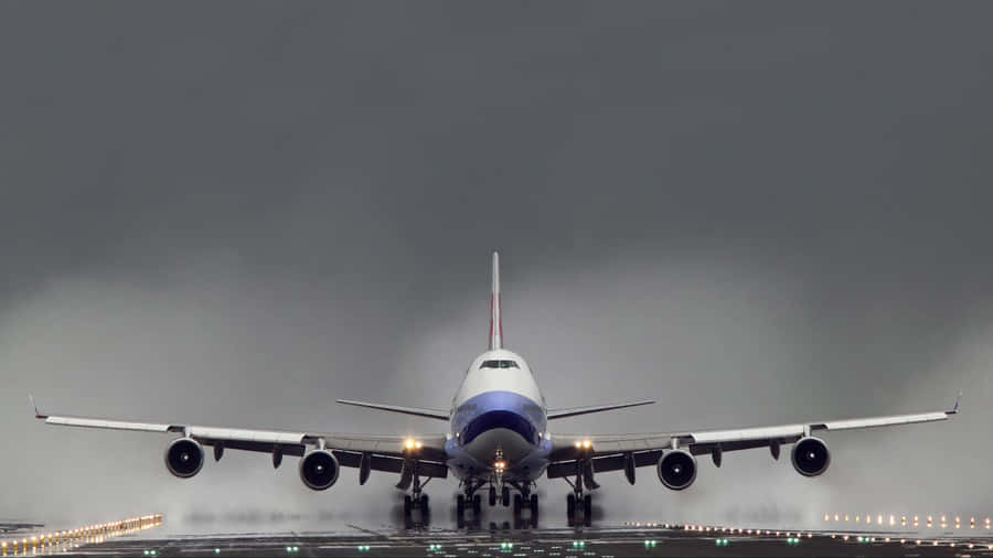 A Majestic Boeing 747 Airplane Seen From Below, Flying Through The Clouds. Wallpaper