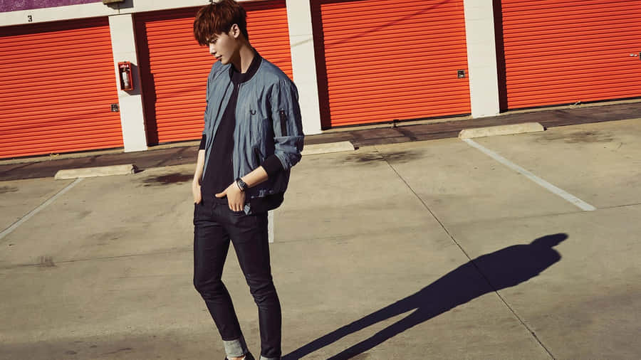 A Man In A Blue Jacket Standing In Front Of A Red Garage Wallpaper