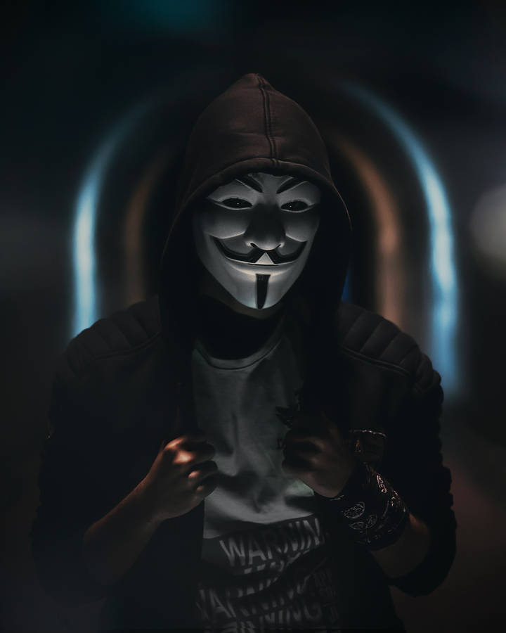 A Man In A Hoodie And Mask Is Standing In A Tunnel Wallpaper