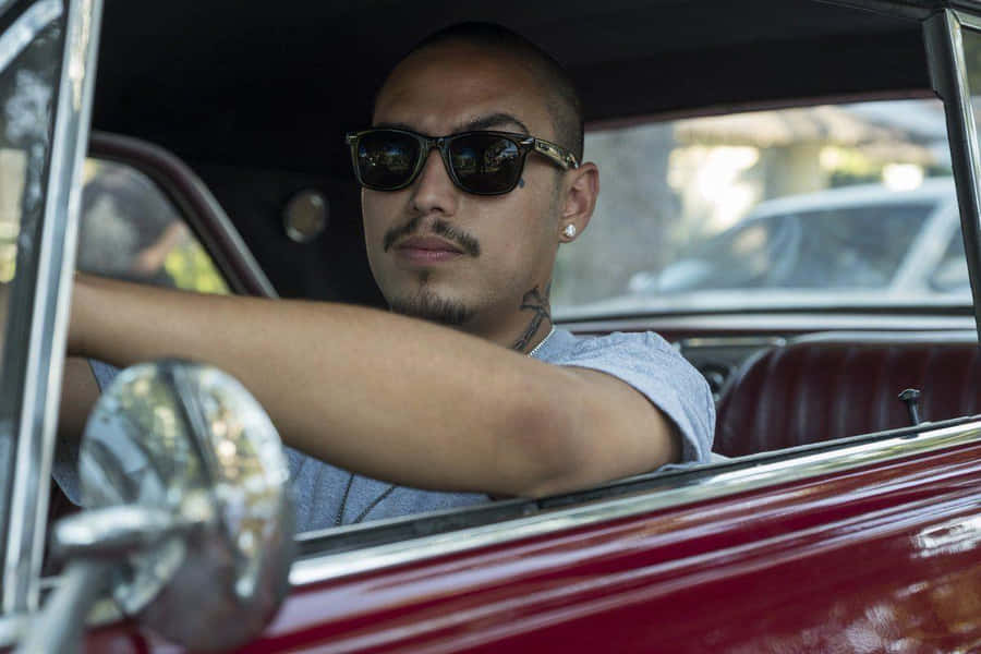 A Man In Sunglasses Driving A Classic Car Wallpaper