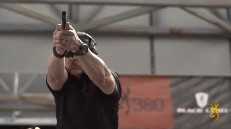 A Man Is Holding A Gun In His Hand Wallpaper