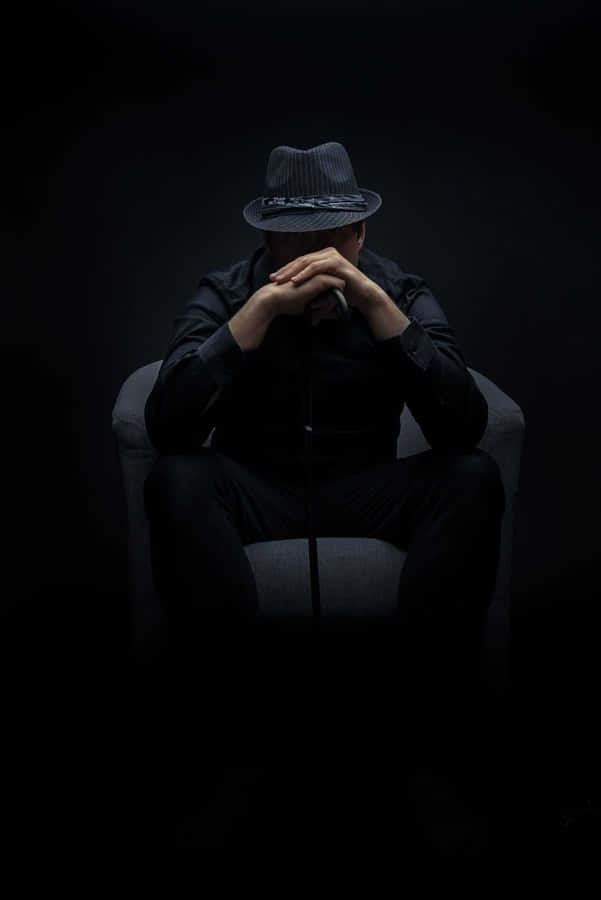 A Man Sitting In A Chair Wallpaper