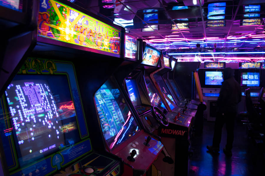 A Man Standing In Front Of A Video Game Room Wallpaper