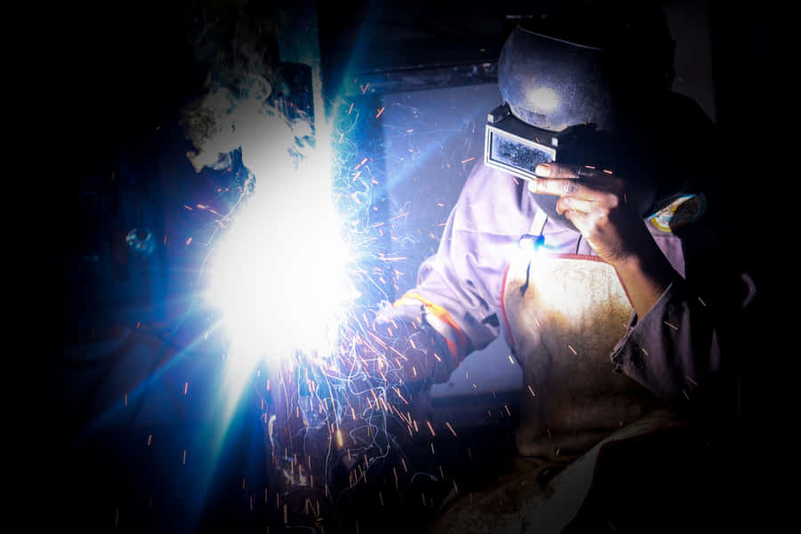 A Man Welding In The Dark Wallpaper