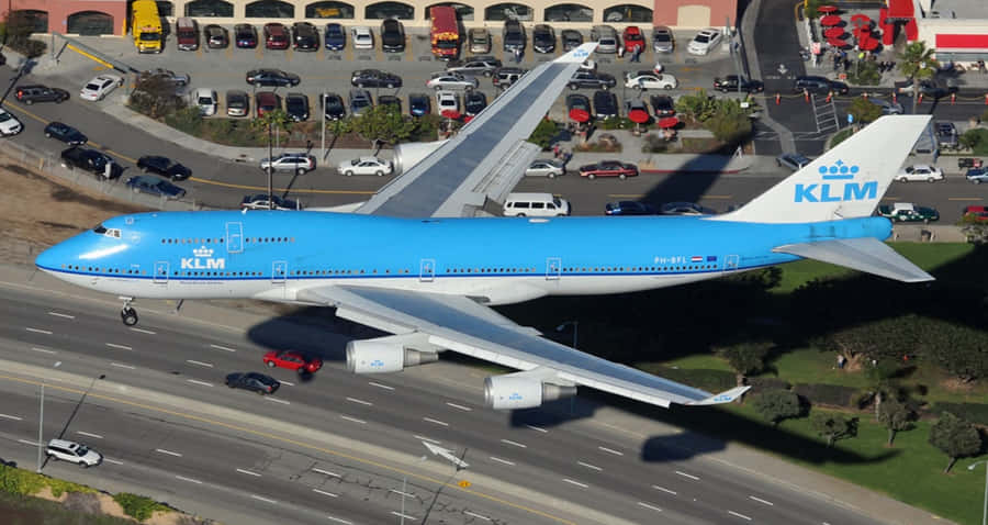 A Massive Boeing 747 Flying High Over The Landscape Wallpaper