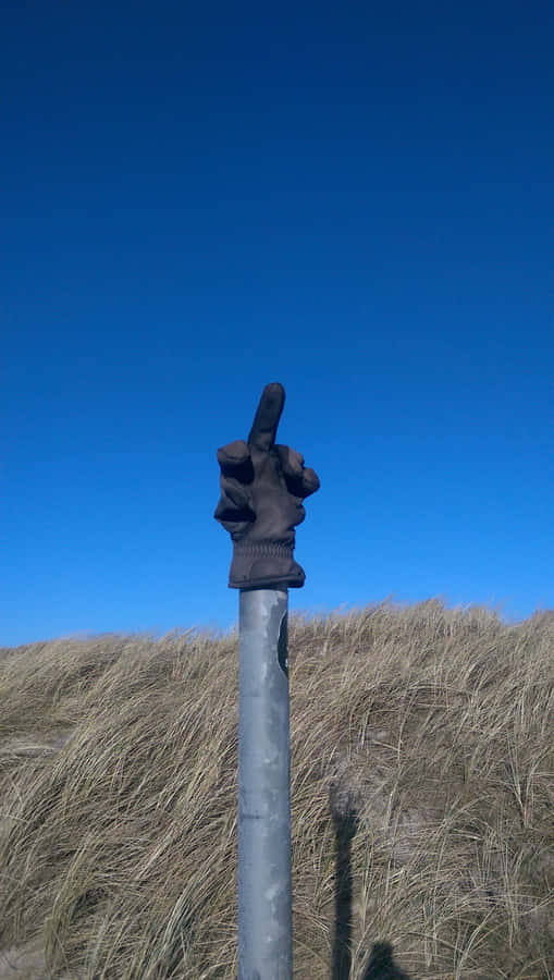 A Metal Pole With A Hand On It Wallpaper