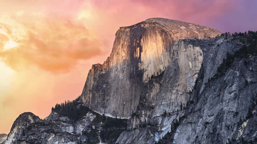 A Mountain With A Colorful Sunset Behind It Wallpaper