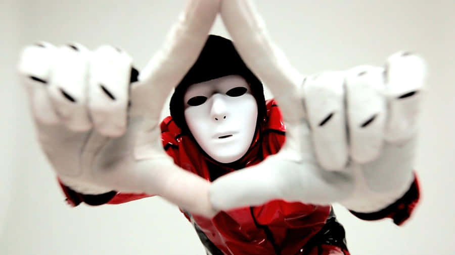 A Person In A Red Mask Making A Hand Gesture Wallpaper