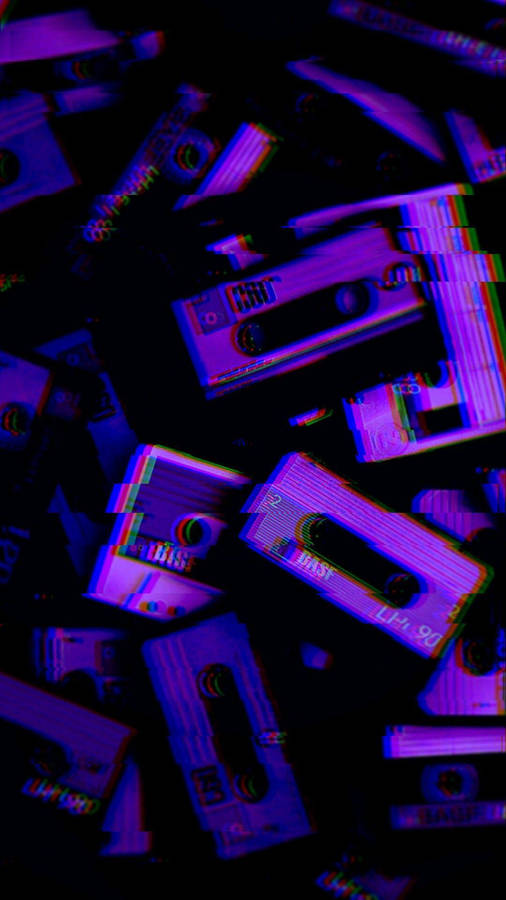 A Pile Of Purple And Blue Cassette Tapes Wallpaper