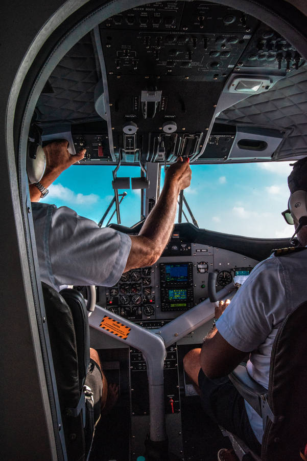 A Pilot Struggling Through A Flight In A Small Airplane Cockpit Wallpaper