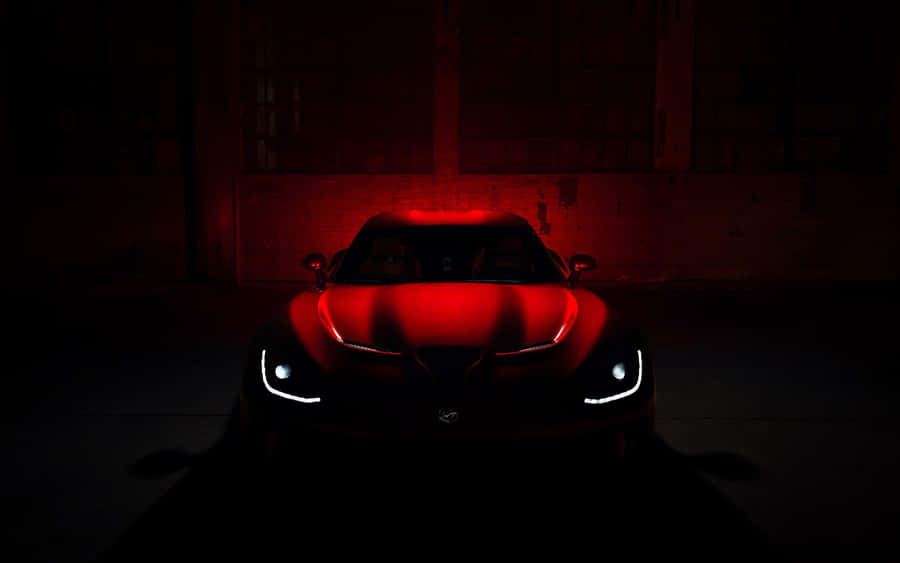 A Red Sports Car Is Lit Up In The Dark Wallpaper
