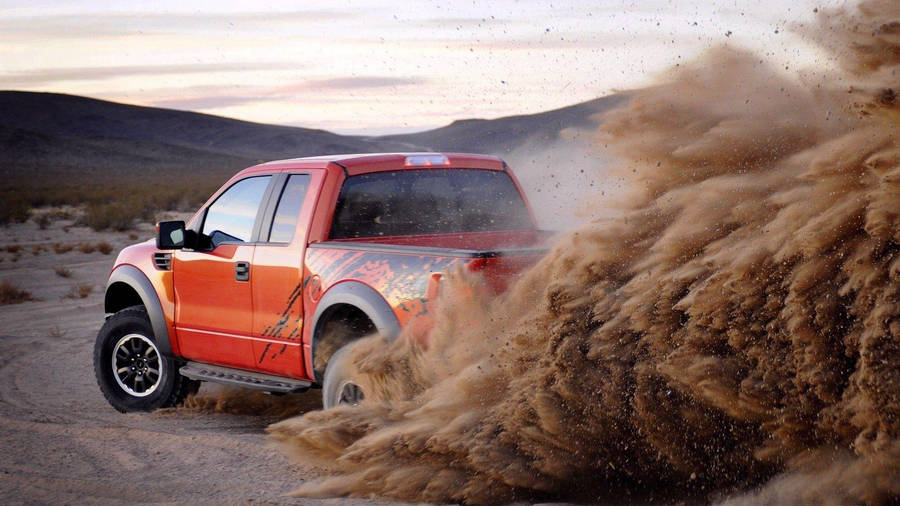 A Red Truck Driving Through A Desert Wallpaper