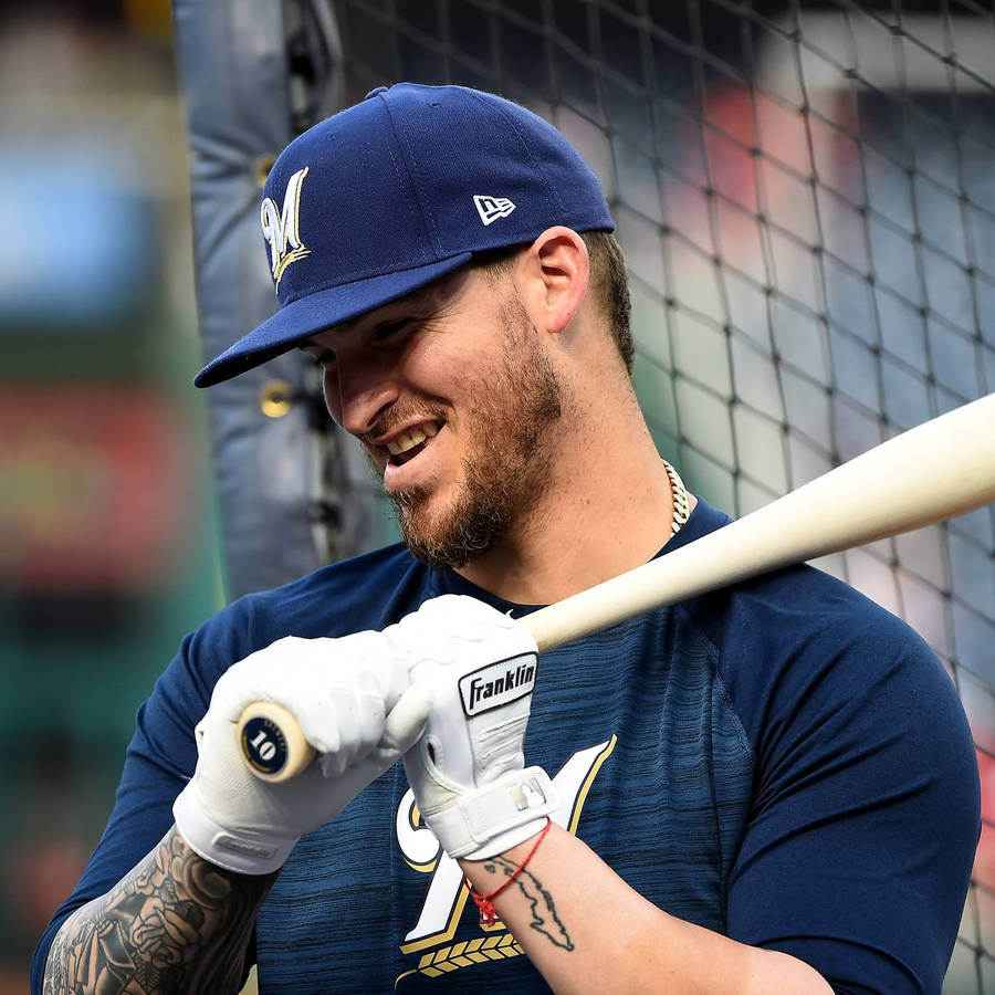 A Smiling Yasmani Grandal Holding A Baseball Bat Wallpaper