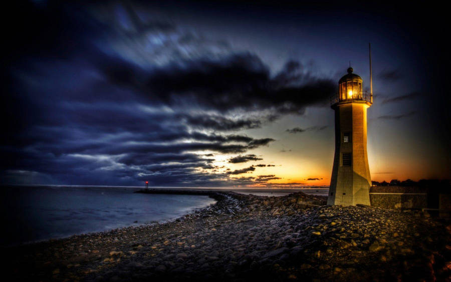 A Solitary Lighthouse Guiding The Way Wallpaper