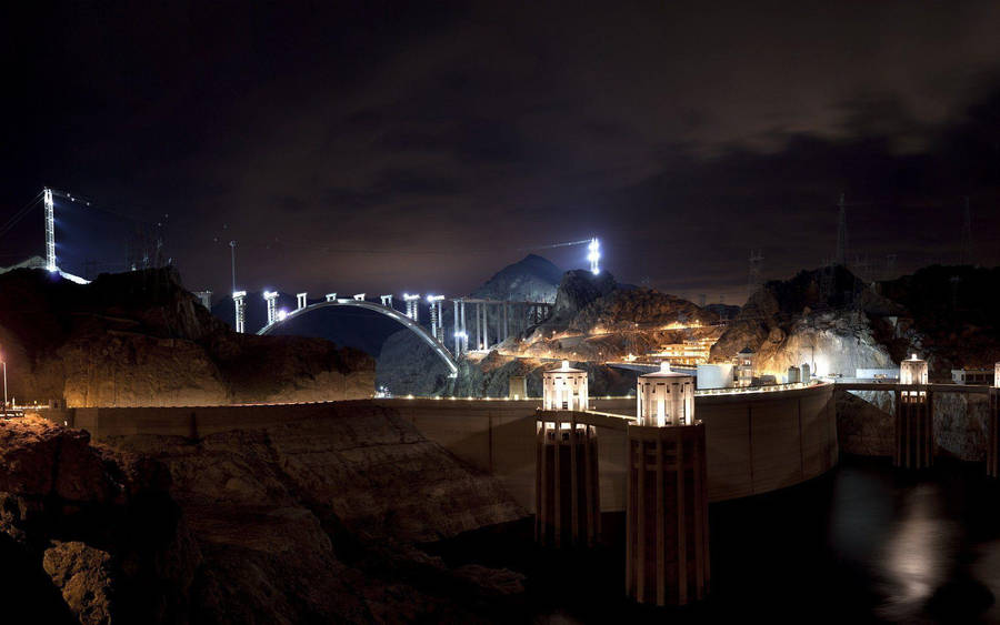 A Spellbinding View Of The Hoover Dam Illuminated At Night. Wallpaper