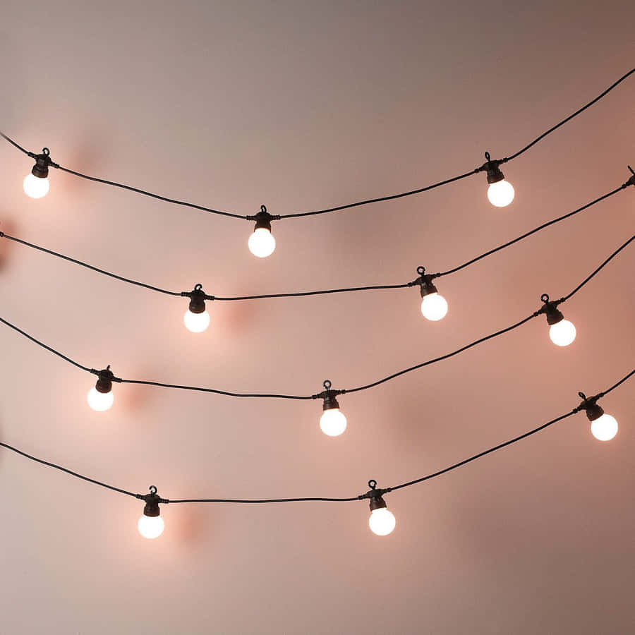 A String Of Lights With A Pink Bulb Wallpaper