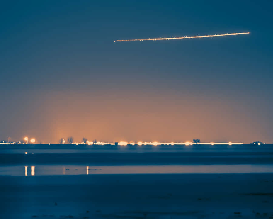 A Stunning Comet Soaring Through The Night Sky Wallpaper