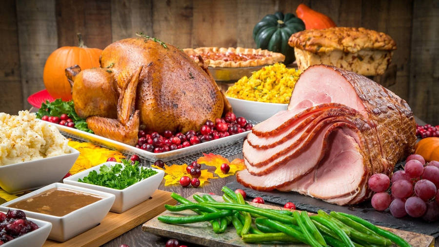 A Sumptuous Feast Of Ham And Roasted Turkey For Dinner Wallpaper