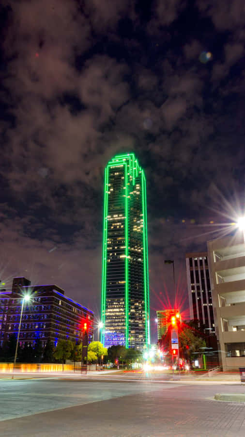 A Tall Building With Green Lights Wallpaper