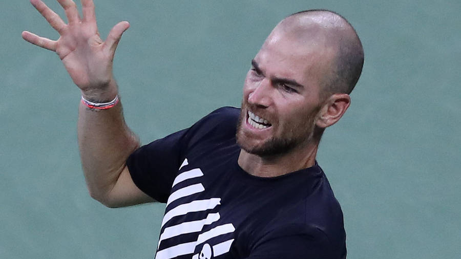 A Tennis Player Is Holding His Racket Up Wallpaper