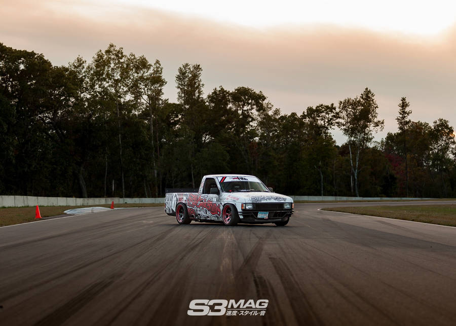 A Truck Driving Down A Track In The Evening Wallpaper