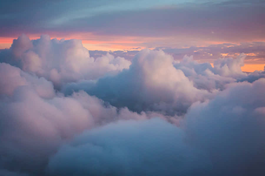 A Vast Sea Of Clouds Cascading Across A Serene Blue Sky. Wallpaper