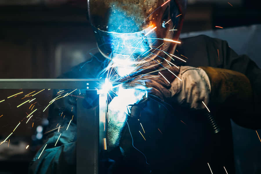 A Welder Is Welding Metal In A Factory Wallpaper