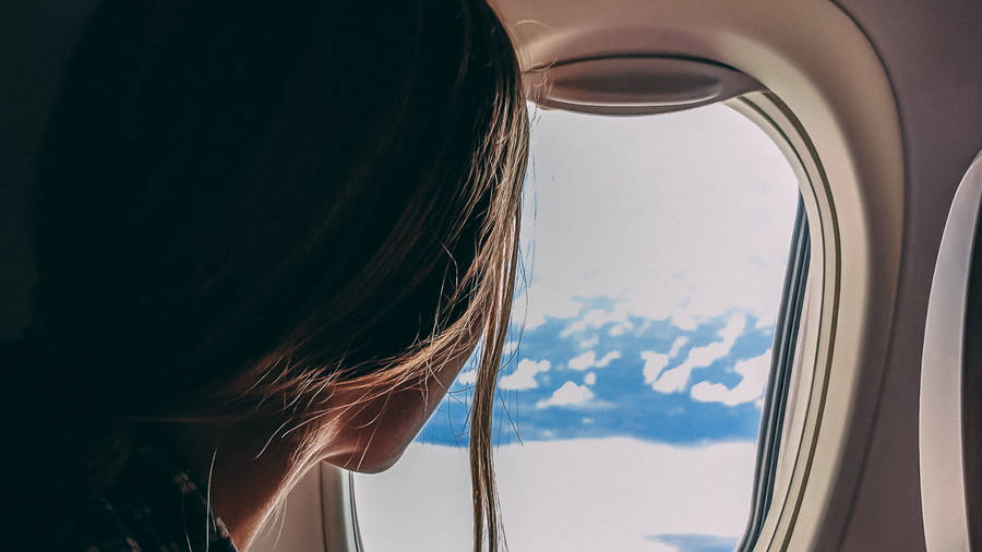 A Woman Beside A Plane Window Wallpaper