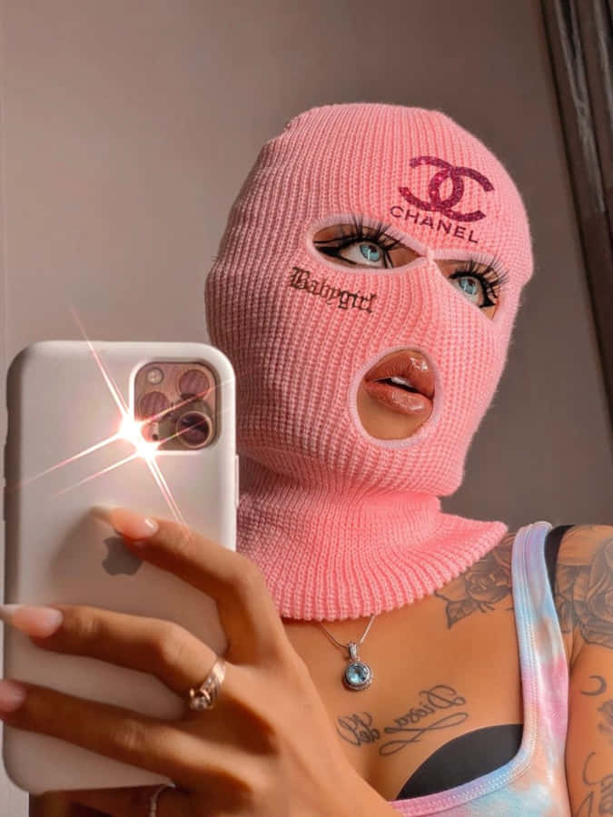 A Woman Wearing A Pink Knitted Mask Taking A Selfie Wallpaper