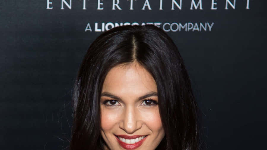A Woman With Long Hair Smiling At The Red Carpet Wallpaper