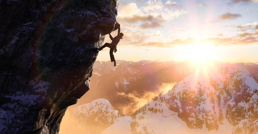 Adventurous Man Conquering Icy Mountain Peaks Wallpaper