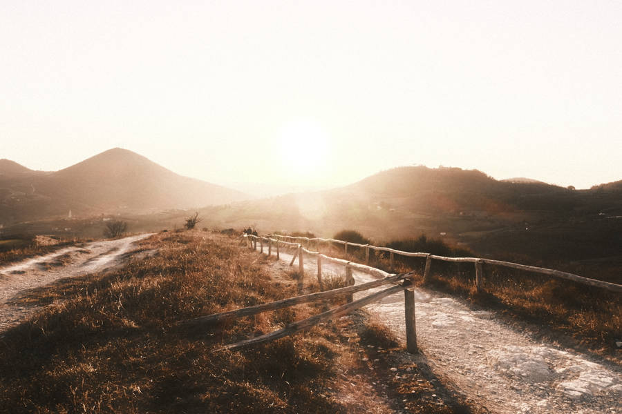 Aesthetic Light Brown Sunlight Over Mountains Wallpaper