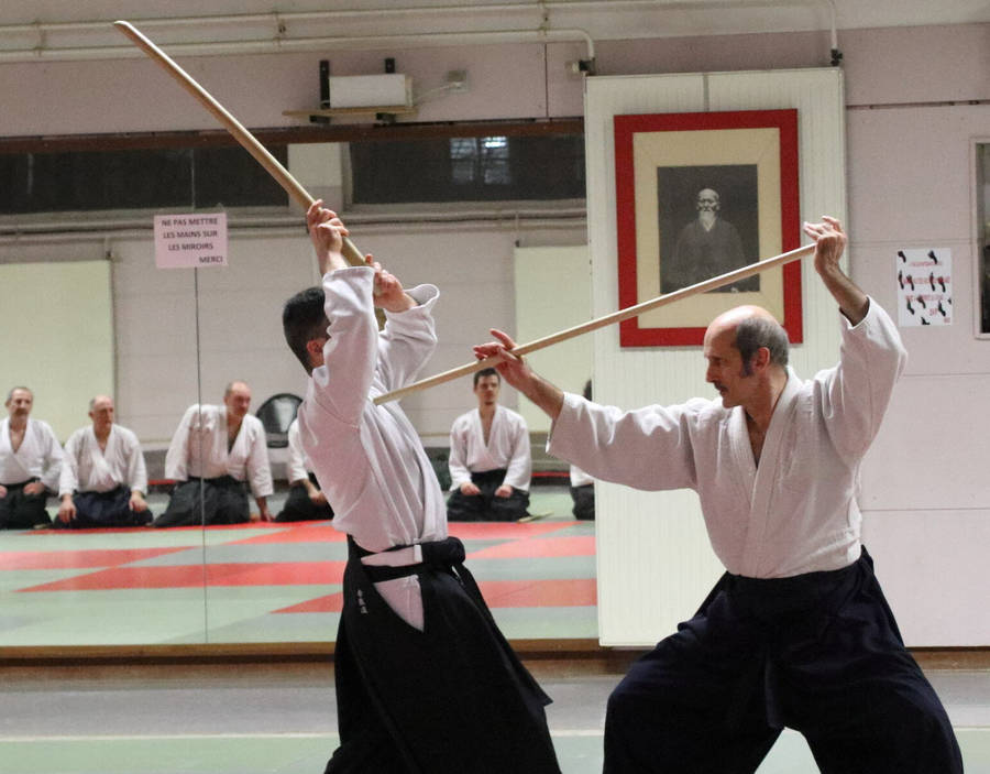 Aikido Master Practicing With Jo Staff In Traditional Dojo Wallpaper