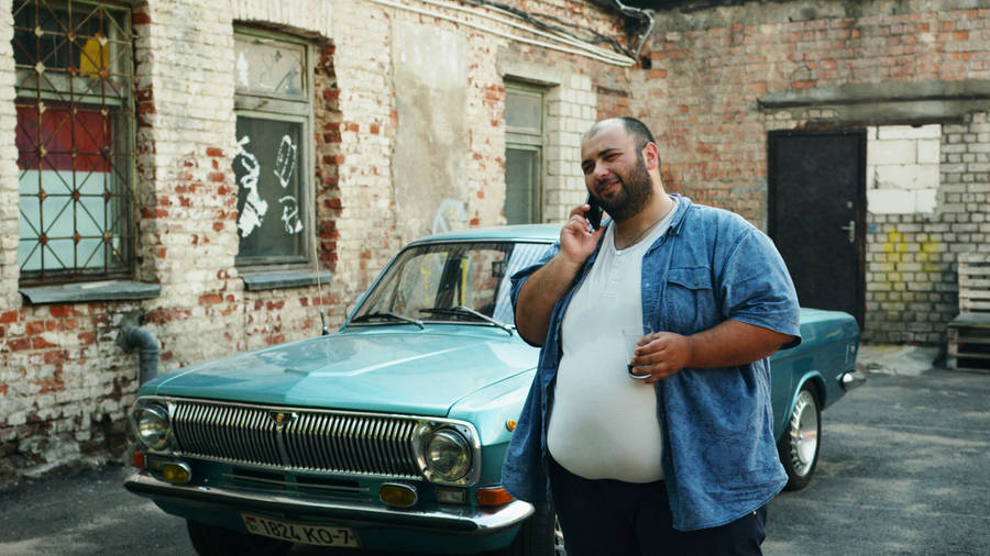 Aloof, Plus-sized Individual Casually Talking Over The Phone Wallpaper