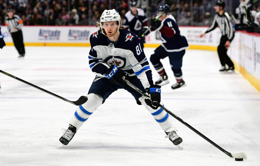 American Ice Hockey Player Kyle Connor Carrying The Puck Wallpaper