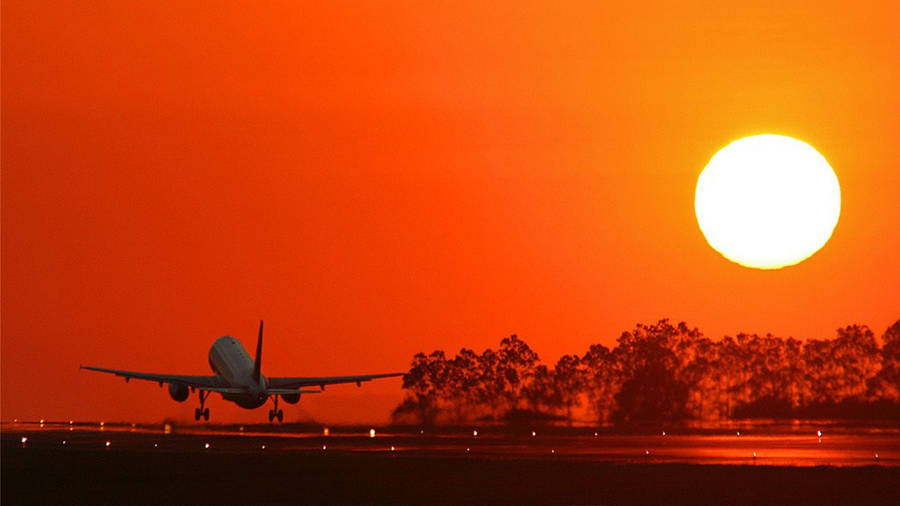 An Aircraft Taking Off Over A Body Of Water. Wallpaper