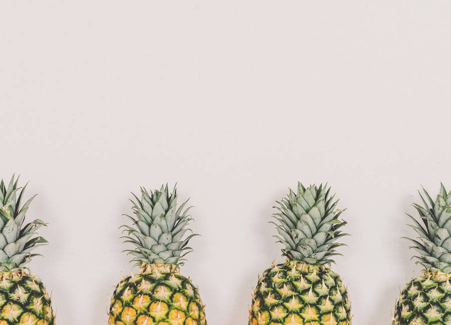 An Array Of Pineapples Of Different Sizes, Shapes, And Colors All Lined Up Side By Side. Wallpaper