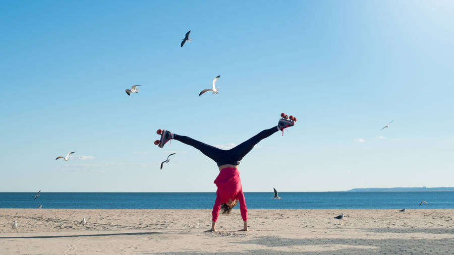 An Athlete Showcasing Tumbling Moves On The Seashore Wallpaper