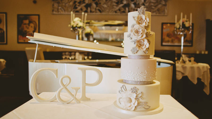 An Exquisite Four-tier White Wedding Cake Adorned With Beautiful Roses. Wallpaper