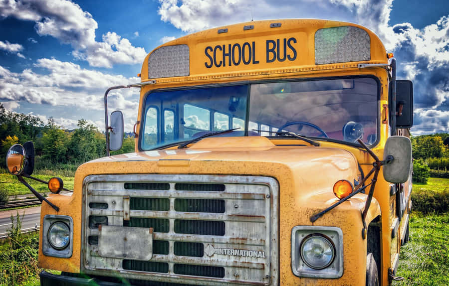 An Old School Bus Parked On A Road Wallpaper