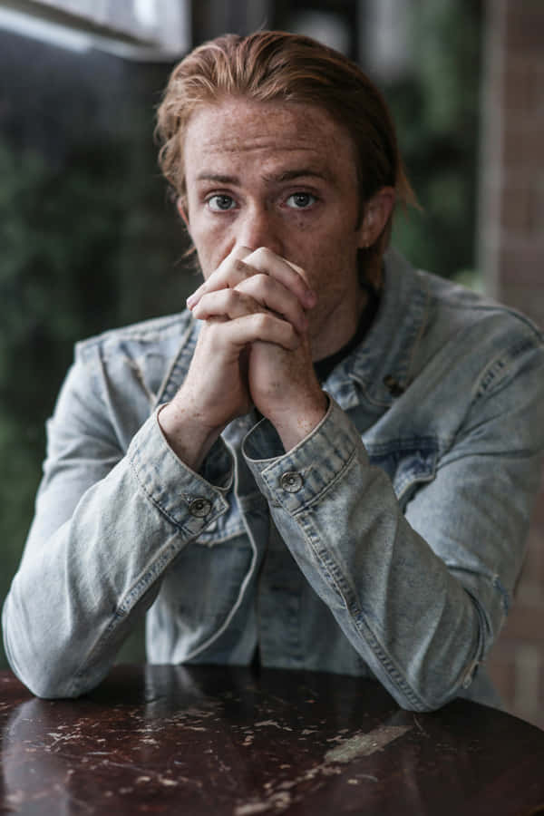 Anxious Man Leaning On Table Wallpaper